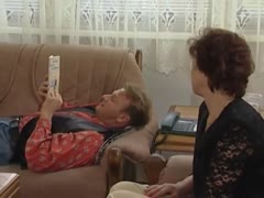 Mann liest am Sofa und Frau will Sex