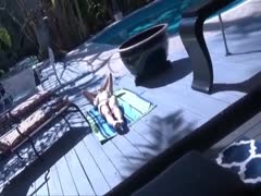 Brünette sonnt sich nackt am Pool